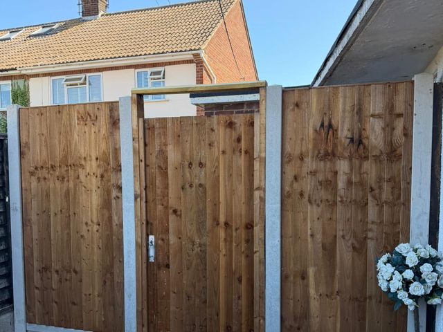 A closeboard side gate set between two closeboard panels on concrete posts